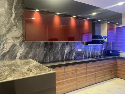 a kitchen with a marble counter top and wooden cabinets at Sbb Star Resources Homestay in Sungai Petani