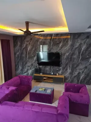 a living room with purple furniture and a tv at Sbb Star Resources Homestay in Sungai Petani