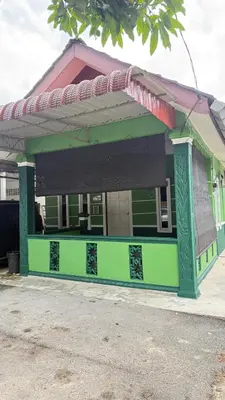 a green building with awning on a street at Mk homestay butterworth in Butterworth