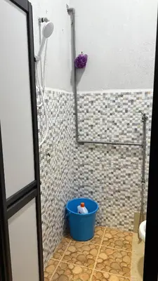 a shower with a blue bucket in a bathroom at Mk homestay butterworth in Butterworth