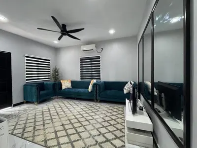 a living room with a blue couch and a ceiling fan at Omah Kebun Private Pool in Sungai Besar