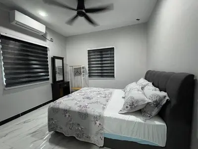 a bedroom with a bed and a ceiling fan at Omah Kebun Private Pool in Sungai Besar