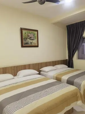 a hotel room with three beds and a ceiling at Nice Emerald Avenue suite in Brinchang