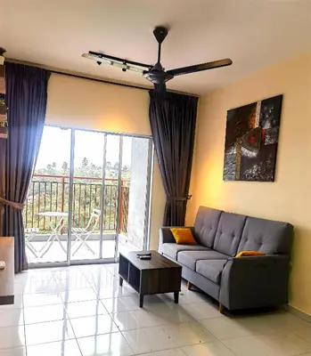 a living room with a couch and a large window at Nice Emerald Avenue suite in Brinchang