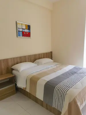 a bedroom with a bed and a picture on the wall at Nice Emerald Avenue suite in Brinchang