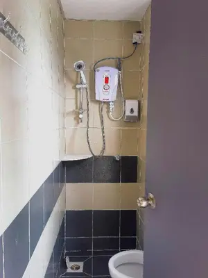 a bathroom with a toilet and a shower in it at Nice Emerald Avenue suite in Brinchang