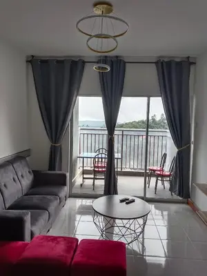 a living room with a couch and a table at Nice Emerald Avenue suite in Brinchang