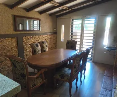 a dining room with a wooden table and chairs at Untaian Kaseh Villa at Tambun by S&S Groups Consultant in Ipoh