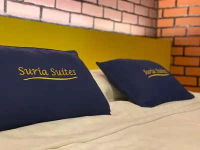 a bed with two blue pillows on top of it at Suria Suites Apartment & Guesthouse in Tanah Rata