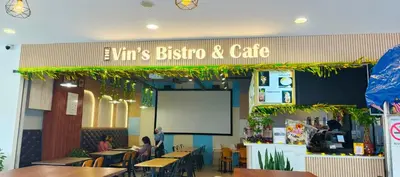 a restaurant with people sitting at tables and a whiteboard at Suria Suites Apartment & Guesthouse in Tanah Rata