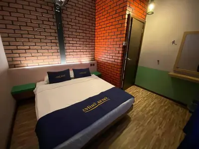 a large bed in a room with a brick wall at Suria Suites Apartment & Guesthouse in Tanah Rata