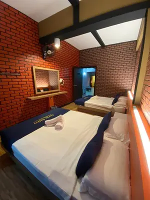a bedroom with two beds in a brick wall at Suria Suites Apartment & Guesthouse in Tanah Rata
