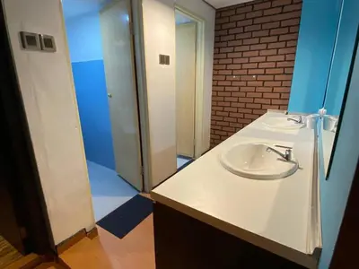 a bathroom with a white sink and a mirror at Suria Suites Apartment & Guesthouse in Tanah Rata