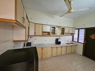 a kitchen with wooden cabinets and a ceiling fan at EasyStay Hostel in Ipoh