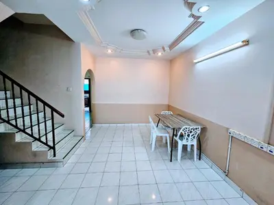 a room with a table and chairs and stairs at EasyStay Hostel in Ipoh