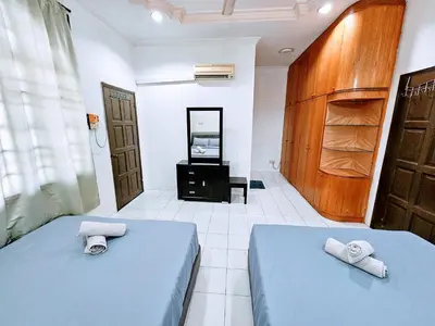 two twin beds in a room with a mirror at EasyStay Hostel in Ipoh