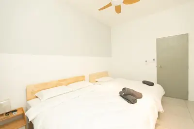 a bedroom with a white bed with a hat on it at Meritus Residensi Seaview Pent Hauz 3BR 10Pax in Perai