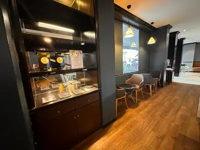 a restaurant with a counter with chairs and a window at Merchant Hotel in George Town