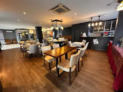 a restaurant with a table and chairs and a bar at Merchant Hotel in George Town