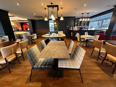 a restaurant with a table and chairs and a bar at Merchant Hotel in George Town