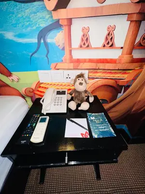 a teddy bear sitting on a table in a bedroom at Merchant Hotel in George Town