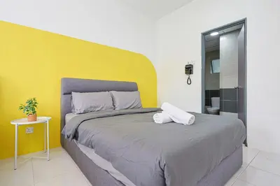 a bedroom with a large bed with a yellow wall at Brinchang Cameron Highland Nest Cool Weather & Cozy 10 Pax Clover Home 8-23A in Brinchang