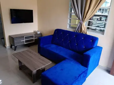 a living room with a blue couch and a table at Rsstay Villa in Lunas