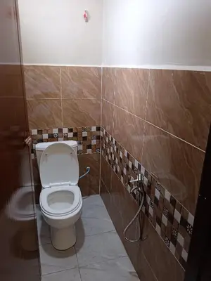 a bathroom with a white toilet in a room at Rsstay Villa in Lunas