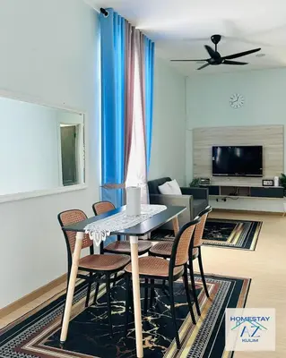 a dining table and chairs in a living room at Homestay AZ Kulim in Kulim