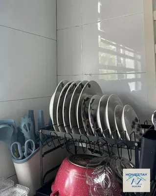 a bunch of dishes on a shelf in a kitchen at Homestay AZ Kulim in Kulim