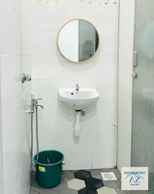 a bathroom with a sink and a mirror and a bucket at Homestay AZ Kulim in Kulim