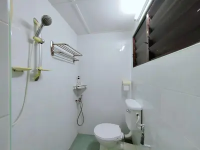 a white bathroom with a toilet and a shower at Ipoh Garden Sunway Guesthouse in Ipoh