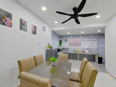 a dining room with a table and a ceiling fan at Ipoh Garden Sunway Guesthouse in Ipoh