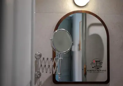 a mirror hanging on a wall next to a sink at Lumut Heritage - a walk to Armenian St Art & Cafes in George Town