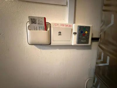 a wall with several electronic devices on a wall at JJ Homestay Taman Manggis in Balik Pulau