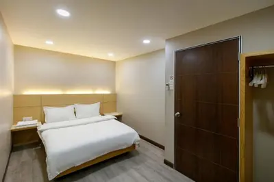 a bedroom with a white bed and a closet at Gaia Realty Homestay, Private & Convenient Stay in Georgetown in George Town