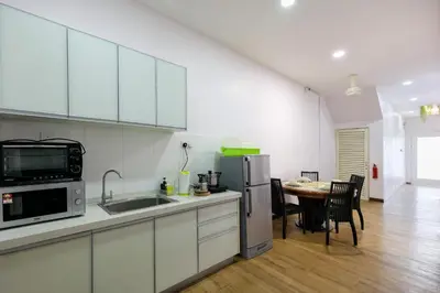 a kitchen with white cabinets and a table with chairs at Gaia Realty Homestay, Private & Convenient Stay in Georgetown in George Town