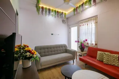 a living room with a couch and flowers on the wall at Gaia Realty Homestay, Private & Convenient Stay in Georgetown in George Town