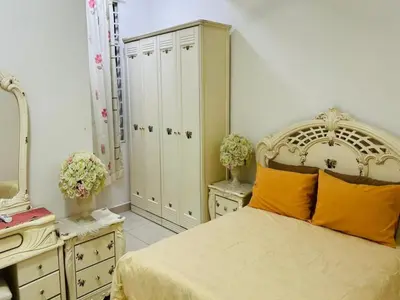 a bedroom with a bed and some cabinets and a mirror at Residensi Seri Pauh in Bukit Mertajam