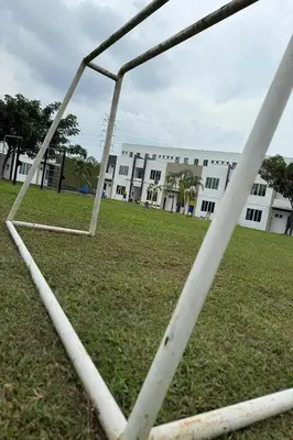 a soccer net in a field in front of a building at Homestay MyKulim in Kulim