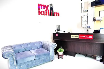 a blue couch in a room with a piano at Homestay MyKulim in Kulim