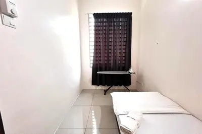 a room with a bed and a table and a window at Homestay MyKulim in Kulim