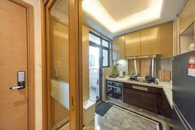a kitchen with wooden cabinets and a window at Princess Cove R&F Luxury apartment with 3 rooms and 2 bathrooms, for 4-6 people, close to the checkpoint, less than 5 minutes away in Gua Sai