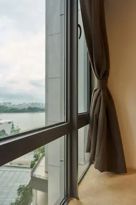 a window with a curtain looking out at the water at Princess Cove R&F Luxury apartment with 3 rooms and 2 bathrooms, for 4-6 people, close to the checkpoint, less than 5 minutes away in Gua Sai
