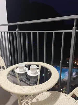 a table and chairs on a balcony with two cups at Sunway Onsen 4-6pax in Kampong Batu Lapan