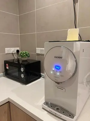 a laptop sitting on a counter next to a microwave at Sunway Onsen Cozy view 4-6pax in Kampong Batu Lapan