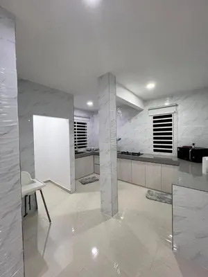 a white kitchen with a table and a chair at BungalowD Pool Villa 7R6B with Netflix Great Movies & Dramas in Ipoh