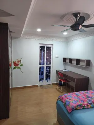 a bedroom with a bed and a table and a ceiling fan at Kinrara HomeStay right at the Heart of Puchong in Gua Sai