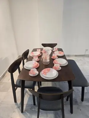 a wooden table with plates and bowls on it at PJ Homestay in Bayan Lepas