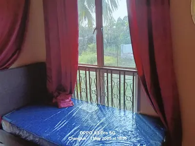 a balcony with a window with red curtains at Zarif homestay in Gua Sai